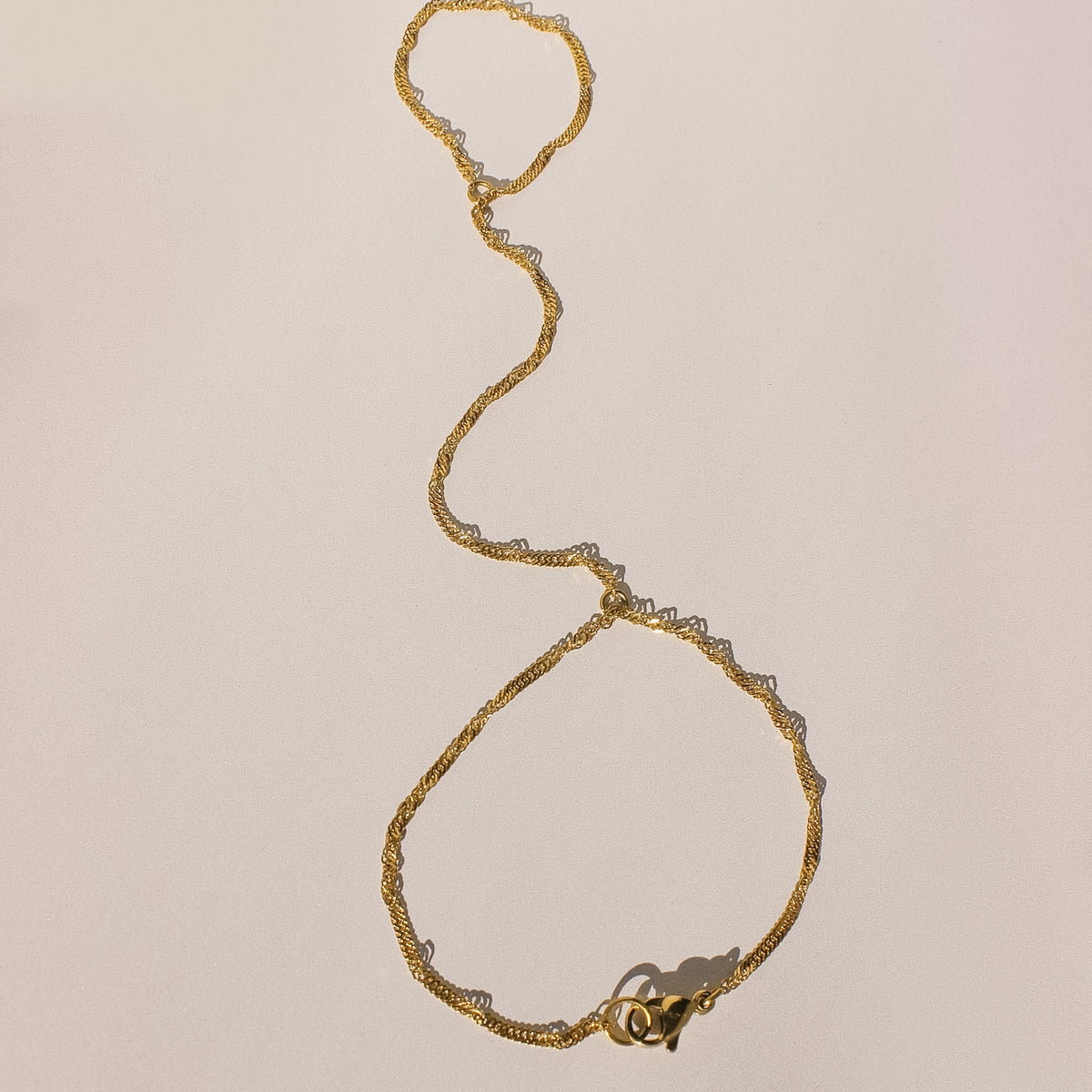Gold bracelet on a beige background