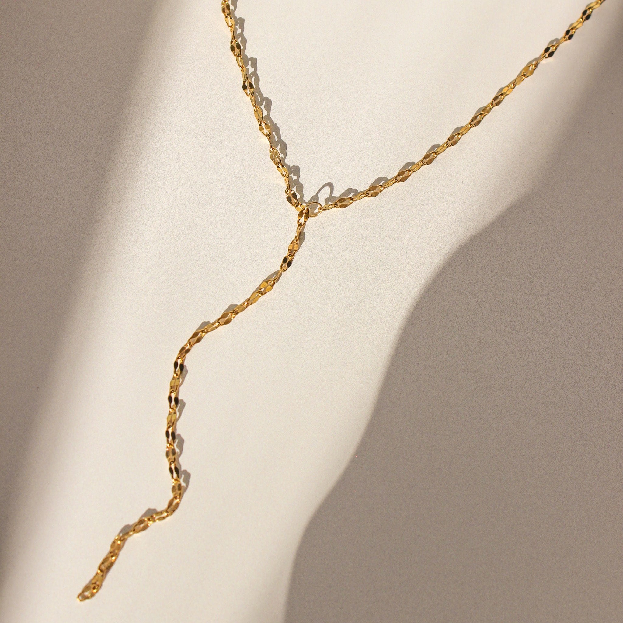 Gold necklace on a beige background