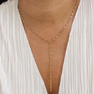 Gold chain necklace worn by a person with a white garment