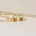 Gold necklace with lock pendants on a light background