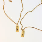 Gold necklaces with '1995' and 'Ariana' tags on a white background